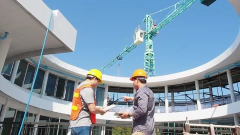 Two young structural engineer and architect dressed in orange work vests. Stock Footage 236826658