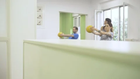 Two young students and instructor exercising the upper body with a wunda chair Video stock 126974727