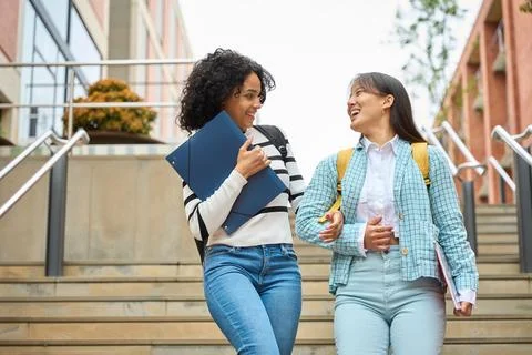Two young students are walking up a set of stairs Stock Photos