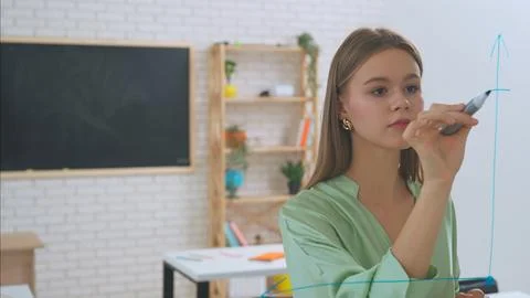 Two young students draw math problems on the glass with a marker and look at Stockfoto's