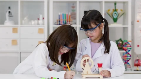 Two Young Students in Lab Coats Conducting Science Experiment Stock Footage 340009509
