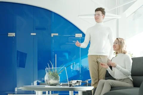 Two young successful software developers in smart glasses scanning information Stock Photos