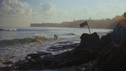 Two young surfers begin to paddle out in the water during the early Stock Footage 105678170