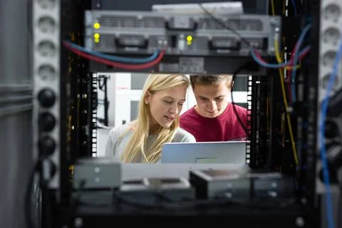  two young technicians working at a data center on server maintenance Two ... Stock Photos