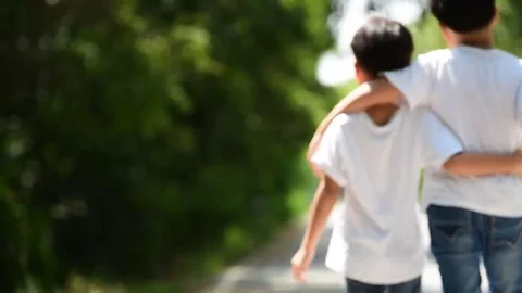 Two young Thai boy walk together on the crack road in the natural park. Vídeos de archivo 69216961