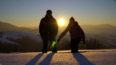 Two young tourists stand in deep snow on the mountain, holding hands and 스톡 동영상 81941355