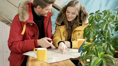 Two young travelers browsing a map indoors. Video stock 97731517