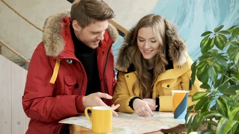 Two young travelers browsing a map indoors. Stock Footage 97731797