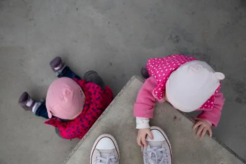 Two young twin sisters playing with shoes Stock Photos
