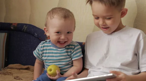 Two young white kids playing with a tablet. Stock Footage 61478288