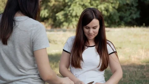 Two young women are preparing a salad of vegetables on the nature. 스톡 동영상 114636033
