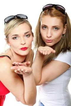 Two young women blowing kisses to the camera Stock Photos