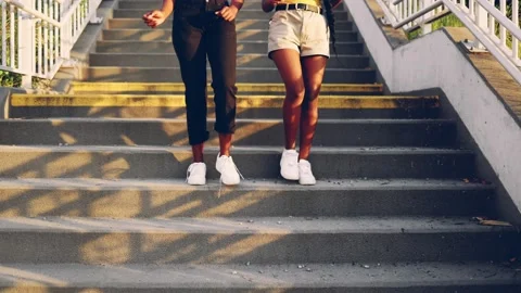 Two young women dance while going down the stairs in the city Stock Footage 161084330
