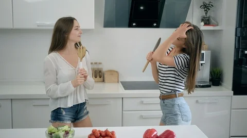 Two young women dancing and singing in the kitchen. Good mood when cooking Video stock 112172005