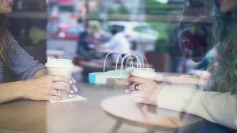Two young women drinking coffee and chatting in cafe. Cameraman reflection in Stock Footage 78483354