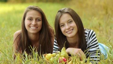 Two young women eat ripe grapes and pear Stock Footage
