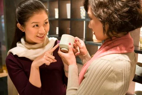 Two Young Women Looking At Objects In Shop Stock Photos