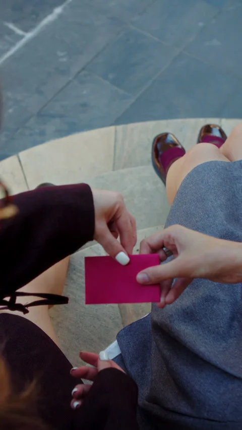 Two young women passing a note outdoors Stock Footage 317174181
