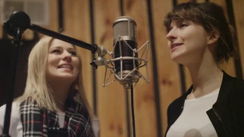 Two Young Women Singing Expressively to the Microphone Stock Footage 74473939