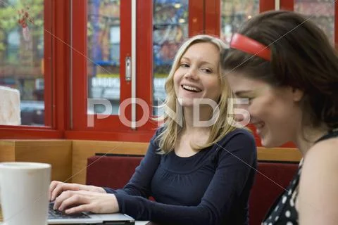 Two young women sitting in a cafe together Stock Photos