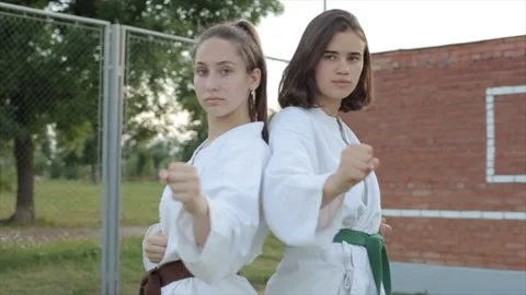 Two young women stand in a basic karate pose with their hands clenched into Stock Footage 140483922