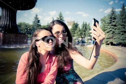 Two young women taking a selfie outdoors Stock Photos