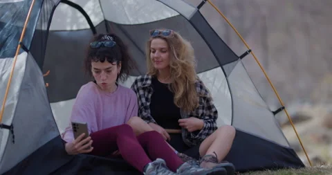 Two Young Women Taking Selfies and Having Fun Inside a Tent While Camping. They Stock Footage 341530962