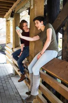 Two young women using a smart phone and being silly taking a self-portrait Stock Photos