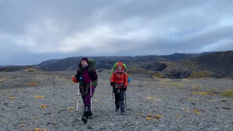 Two young women walk through the lava fields of Kamchatka Stock Footage 140895341