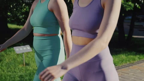 Two Young Women Walking Side By Side In Sunny Park Vídeo Stock 336965936