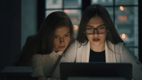 Two young women working with laptop at night Stock Footage 115604553