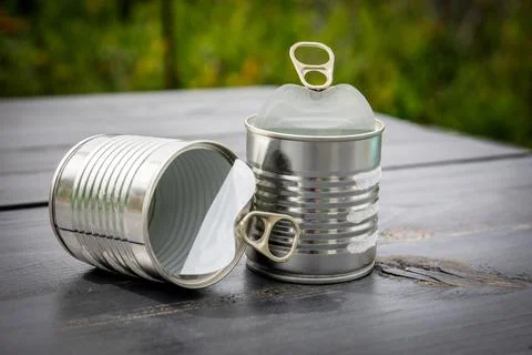 Twp empty and opened cans on wooden table Stock Photos