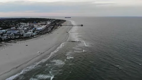 Tybee island beach pier container ship sunset ocean jetty aerial drone Stock Footage 153185408