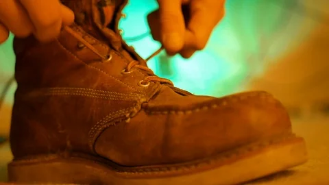 Tying work or hiking boots with colorful background. Stock Footage
