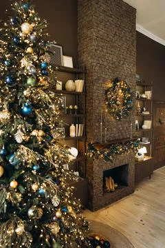 Tylish holiday scene featuring a decorated Christmas tree with lights, a stone Stock Photos