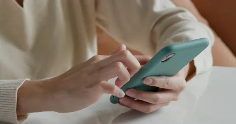 Type on the cellphone and sit on sofa Stock Footage 131760187