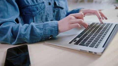 Typeing on laptop keyboard and receiving message in smartphone Working at home Stock Footage 103285762