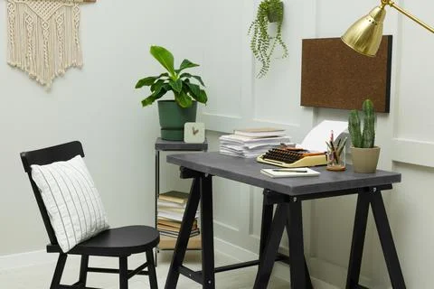 Typewriter and stack of papers on dark table in room. Writer's workplace 스톡 사진