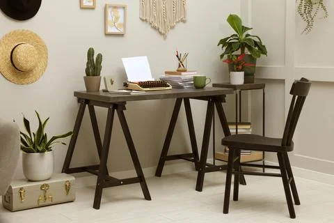 Typewriter and stack of papers on dark table in room. Writer's workplace Foto stock