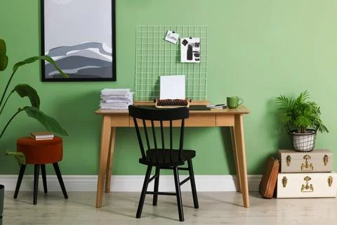 Typewriter, stack of papers and mood board on wooden table near pale green .. Foto stock
