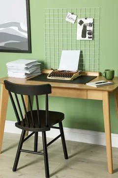 Typewriter, stack of papers and mood board on wooden table near pale green .. Stock Photos