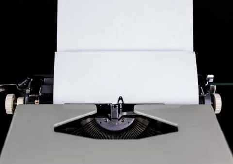 Typewriter on the table on a black background with white paper with empty space Stock Photos