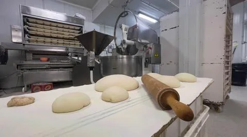 Typical baker's utensils in front of the bread making machines. Concept bread. Stock Photos