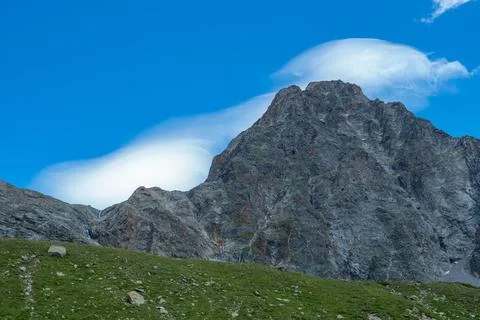 Typical clouds surrounding a peak during foehn, a stormy wind in Switzerland Stock Photos