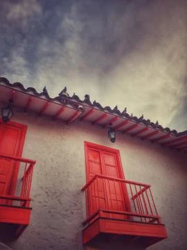 Typical colonial architecture with red windows and balconies with pigeons Stock Photos
