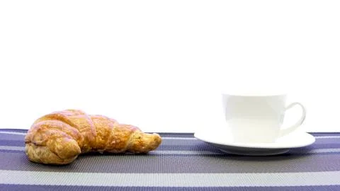 Typical Croissant on pattern table mat and cup of coffee Stock Photos
