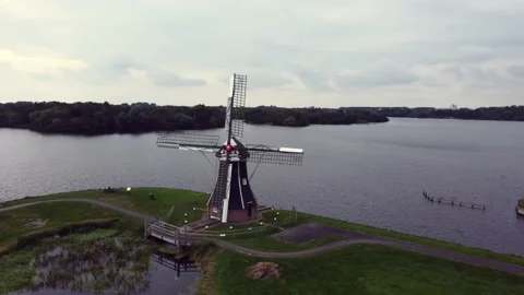 Typical Dutch windmill De Helper in front of the Paterswoldermeer lake. Video stock 163166721