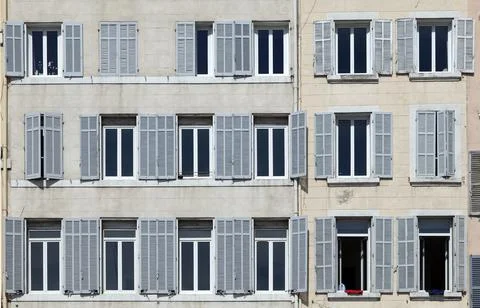 Typical facade of an old hotel with open and closed shutters Stock Photos