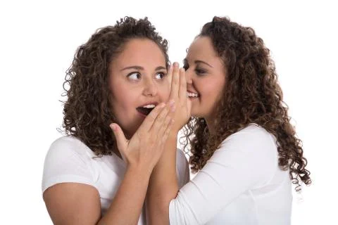 Typical girlfriends talking about secrets: two girls isolated. Stock Photos