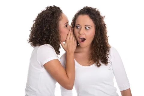Typical girlfriends talking about secrets: two girls isolated. Stock Photos